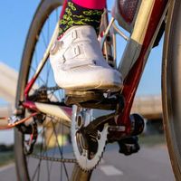 Close-up of a cyclist’s shoe clipped into the pedal, wearing colourful socks, showing the quality and detail of custom cycling clothing by TD Sportswear.