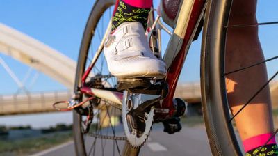 Close-up of a cyclist’s shoe clipped into the pedal, wearing colourful socks, showing the quality and detail of custom cycling clothing by TD Sportswear.