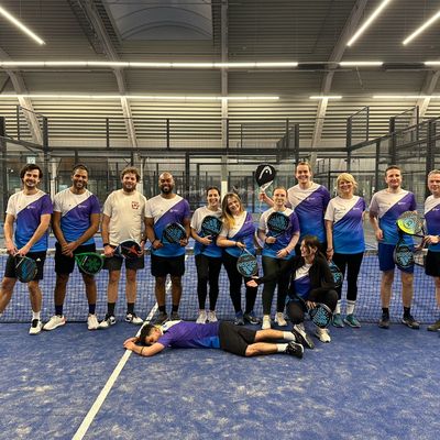 Padel en tennis shirts ontwerpen en bedrukken met eigen logo en ontwerp - klant foto paars wit blauw shirt op padel baan team