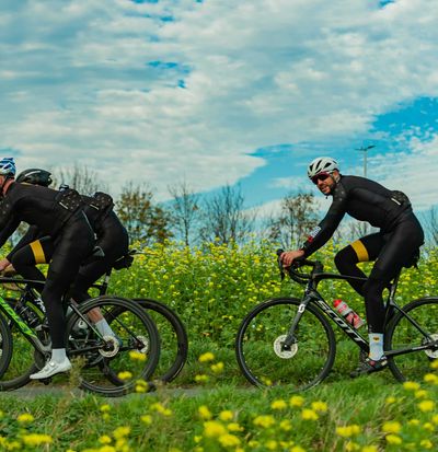 Ciclisti con maglie personalizzate che pedalano in campagna