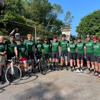 Team ciclistico con maglie personalizzate verdi in posa con bici da corsa all'aperto
