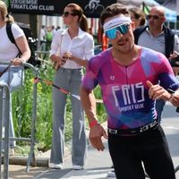 Triatleta Fris con trisuit personalizzata in rosa e blu durante una gara