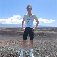 Triatleta con trisuit personalizzata in piedi all'aperto in un paesaggio aperto durante l'allenamento