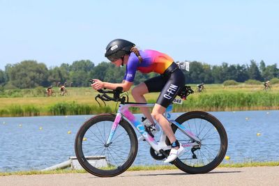 Donna che indossa un body triathlon personalizzato Q-FIN Elite 1200 durant il triathlon