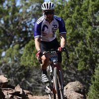 Ciclista de PJAMM con maillot personalizado montando una bicicleta gravel por un sendero rocoso al aire libre