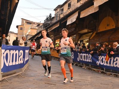Corridori della PTC selectie con maglie da corsa personalizzate durante una gara in un evento cittadino con spettatori