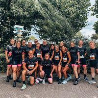 Team wearing custom running and cycling clothing in black posing together before event outdoors