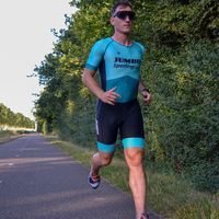 Atleta Jumbo Sperling con trisuit personalizzata che corre su strada durante l'allenamento